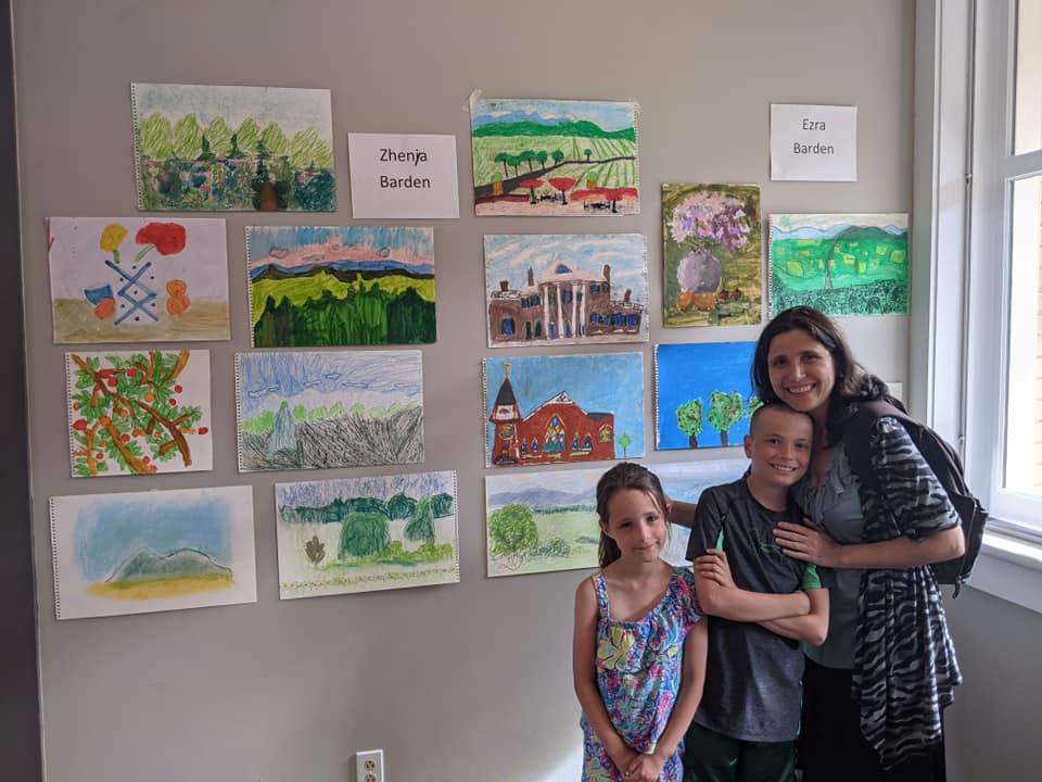 Mom and two kids showing their work at the historic Orange Train Station
