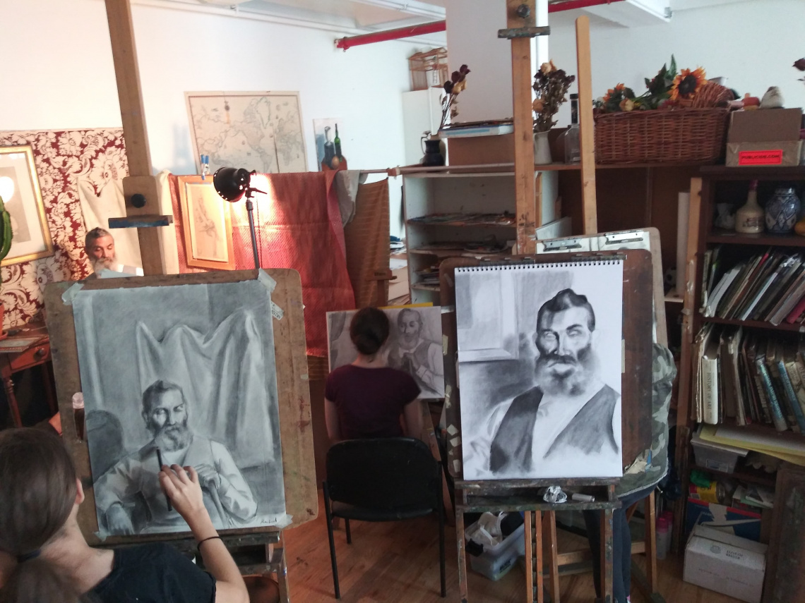 Teens drawing portrait from life during a master class.